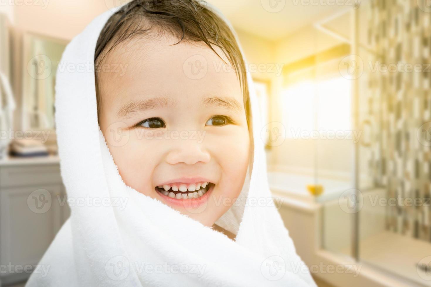 Happy Cute Mixed Race Chinese and Caucasian Boy In Bathroom Wrapped In A Towel photo