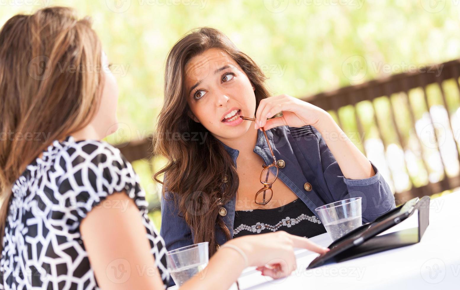 Expressive Young Adult Girlfriends Using Their Computer Electronics Outdoors photo