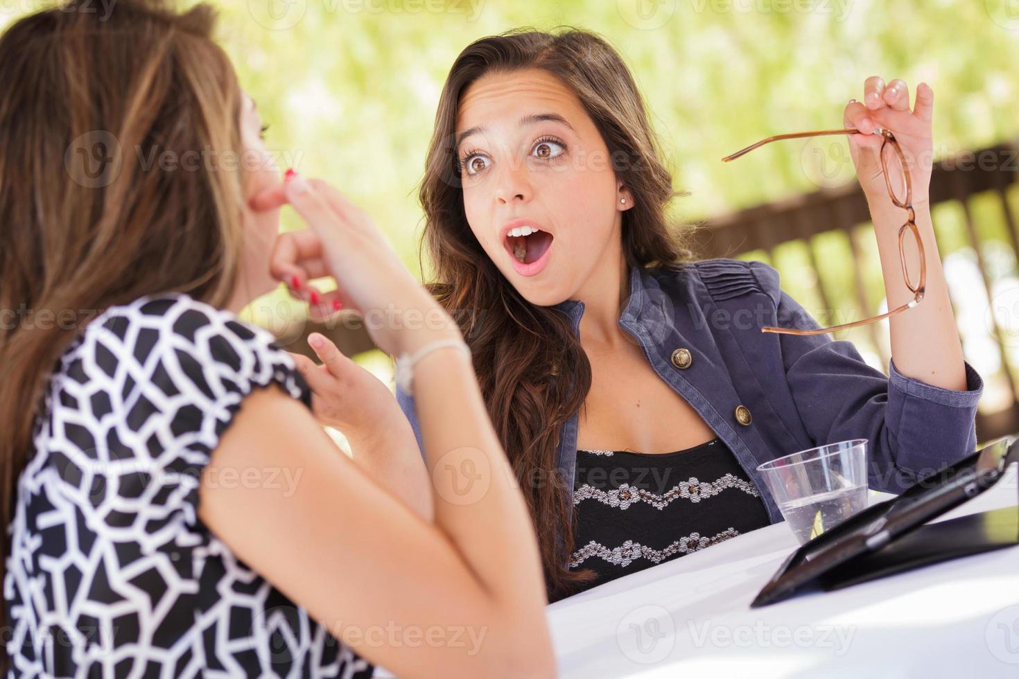 Expressive Young Adult Girlfriends Using Their Computer Electronics Outdoors photo