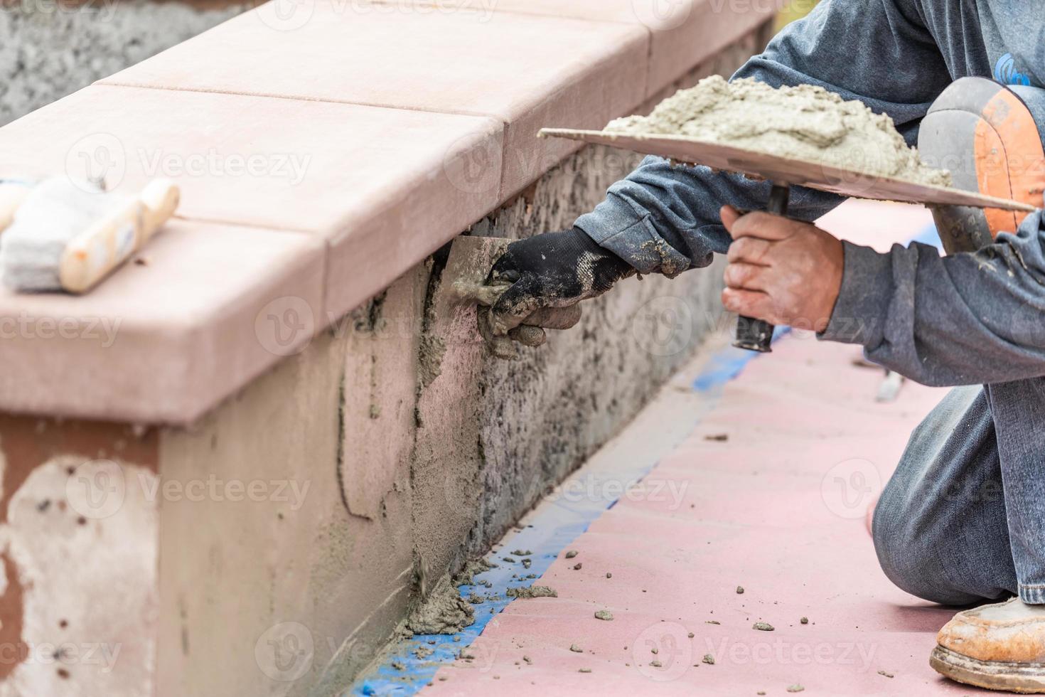 Tile Worker Applying Cement with Trowel at Pool Construction Site photo