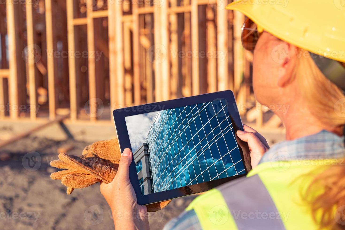 trabajadoras de la construcción revisando el edificio en la almohadilla de la computadora en el sitio de construcción foto