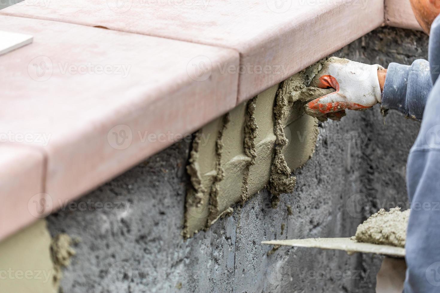 Tile Worker Applying Cement with Trowel at Pool Construction Site photo