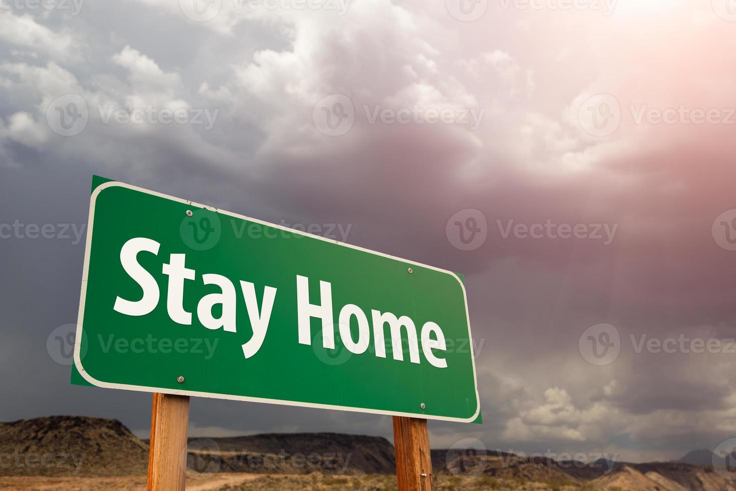 Stay Home Green Road Sign Against Ominous Stormy Cloudy Sky photo