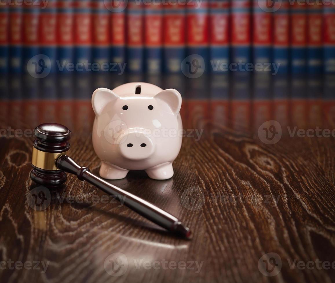 Gavel and Piggy Bank on Wooden Table With Law Books In Background photo