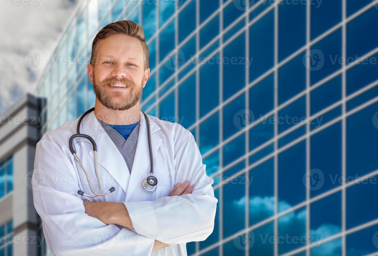 Handsome Young Adult Male Doctor With Beard In Front of Hospital Building photo