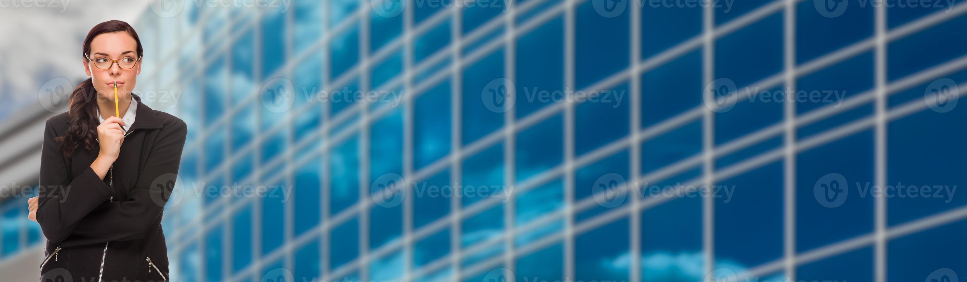 Mixed Race Businesswoman With Pencil Looking To The Side In Front of Corporate Building Banner photo