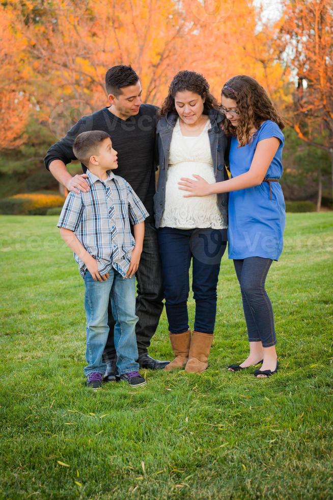 Hispanic Pregnant Family Portrait Against Fall Colored Trees photo