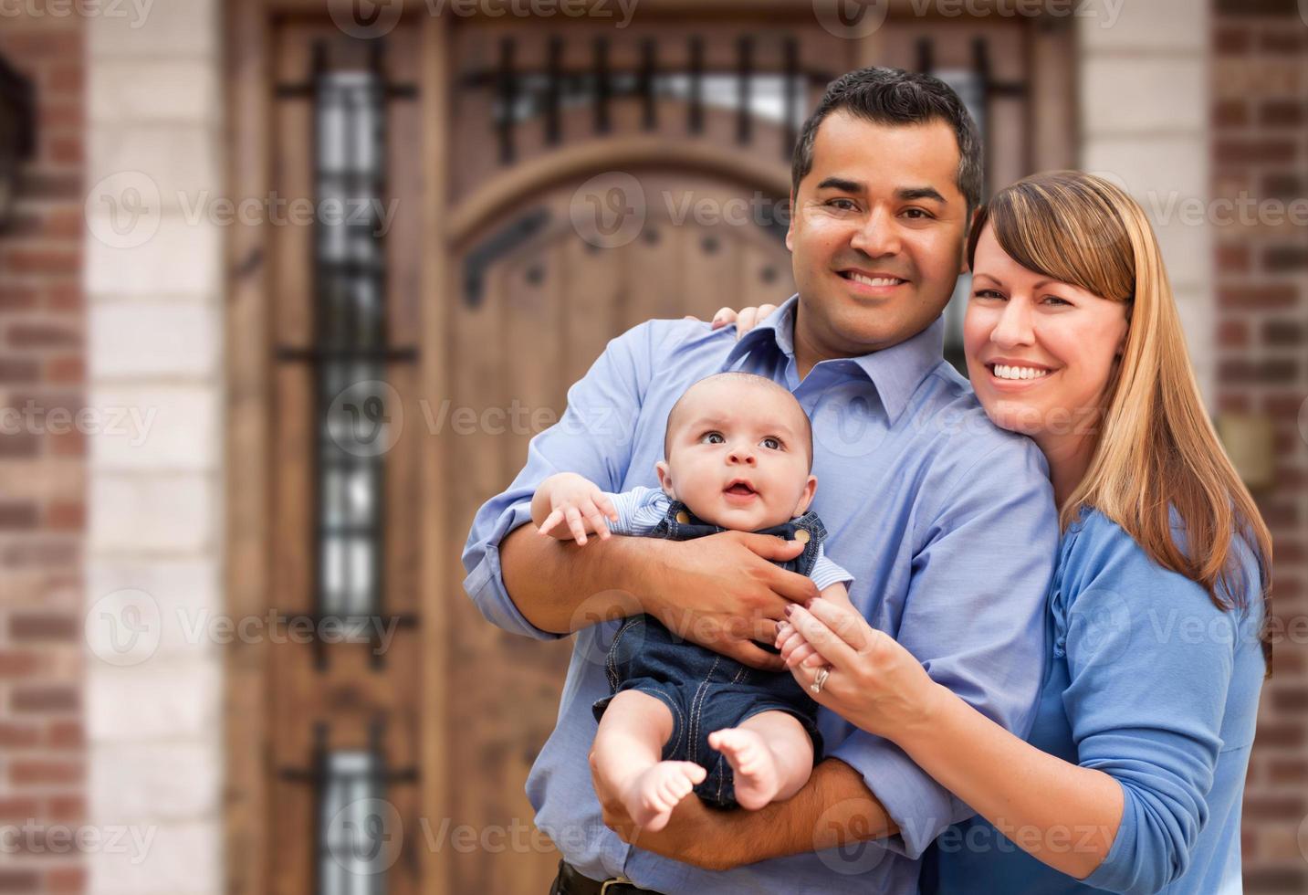 Happy Mixed Race Couple with Baby in Front of House photo