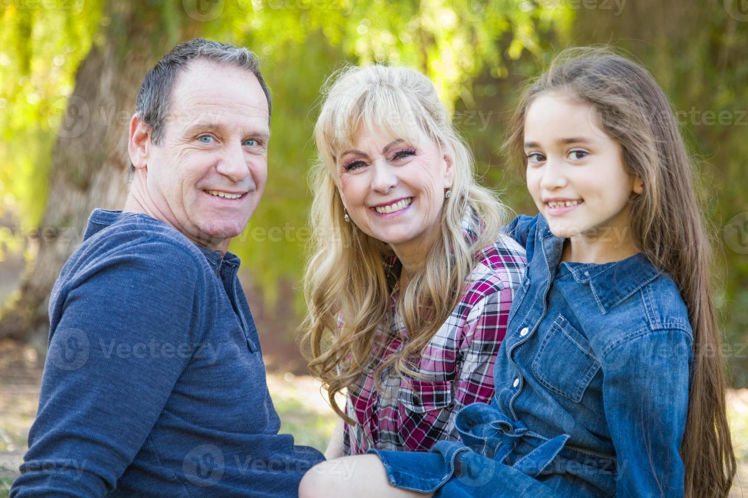 abuela caucásica y abuelo con una joven nieta de raza mixta al aire libre foto