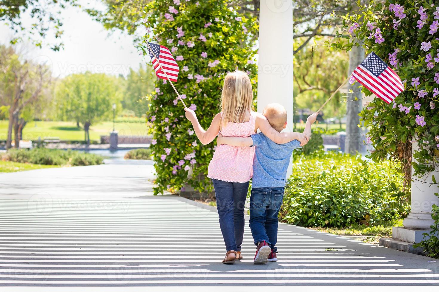 Young Sister and Brother Waving American Flags At The Park photo