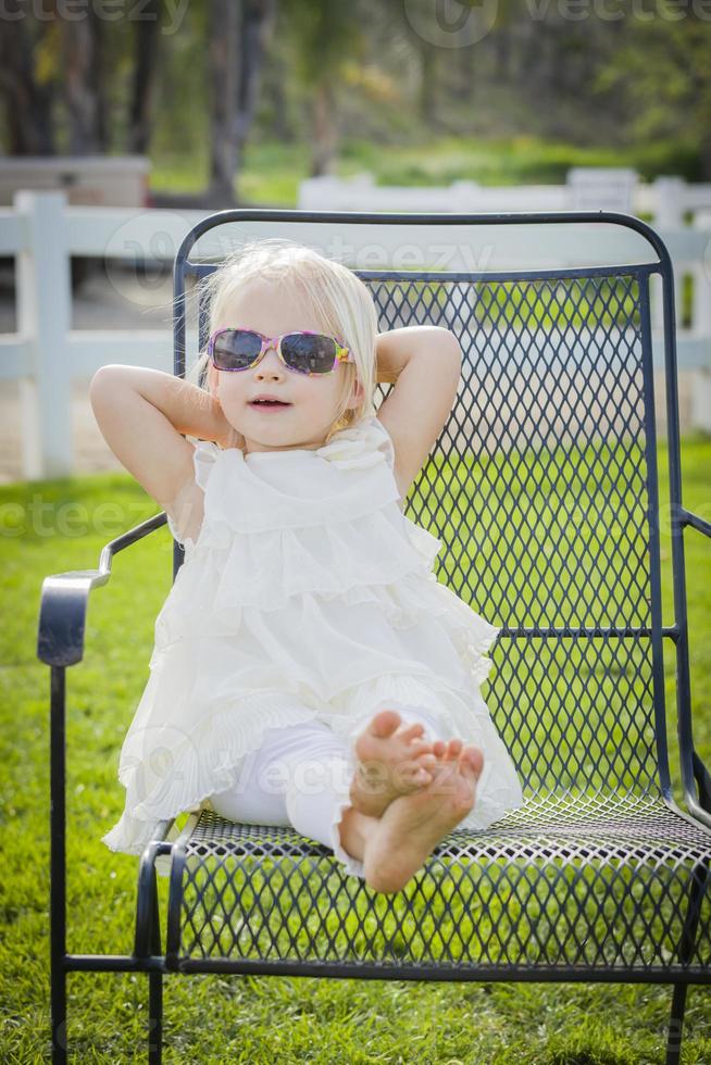 Cute Playful Baby Girl Wearing Sunglasses Outside at Park photo