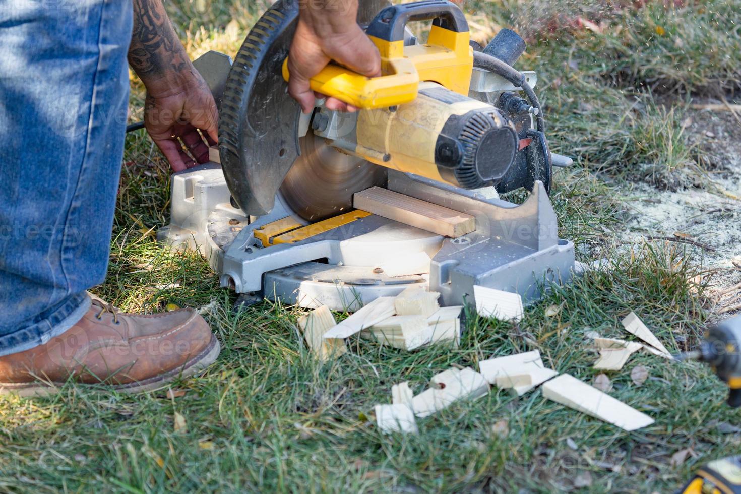 Worker Using Electric Miter Saw At Constrcution Site photo