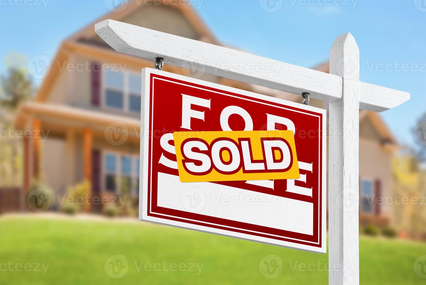 casa vendida en venta letrero de bienes raíces frente a una hermosa casa nueva foto