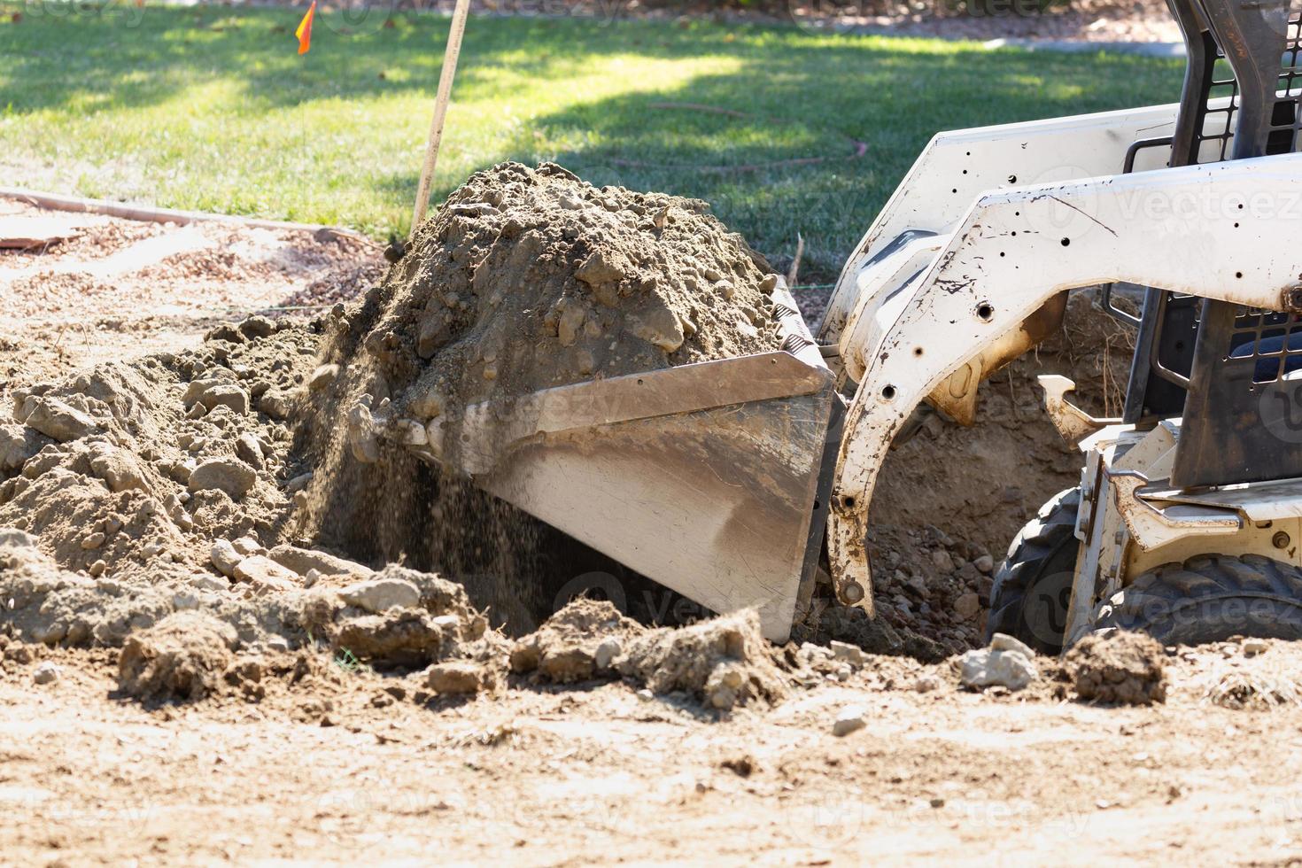 Small Bulldozer Digging In Yard For Pool Installation photo