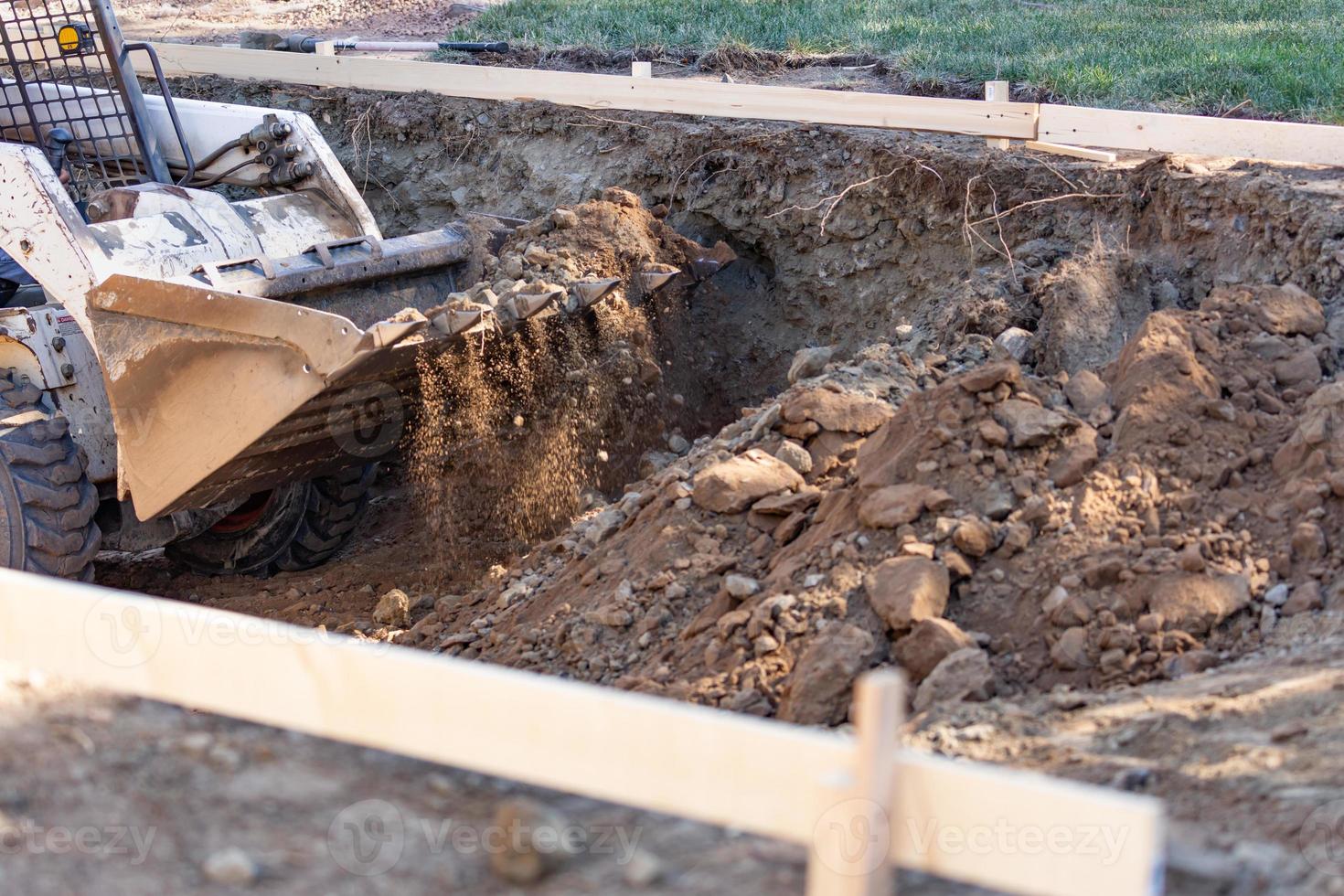 Small Bulldozer Digging In Yard For Pool Installation photo