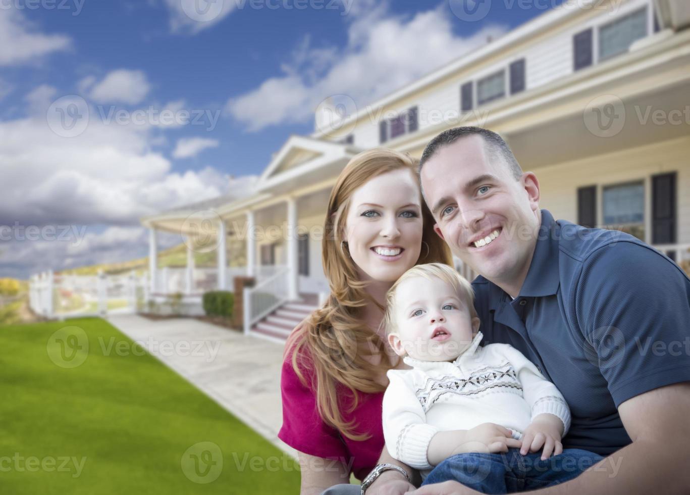 joven familia militar frente a una hermosa casa foto