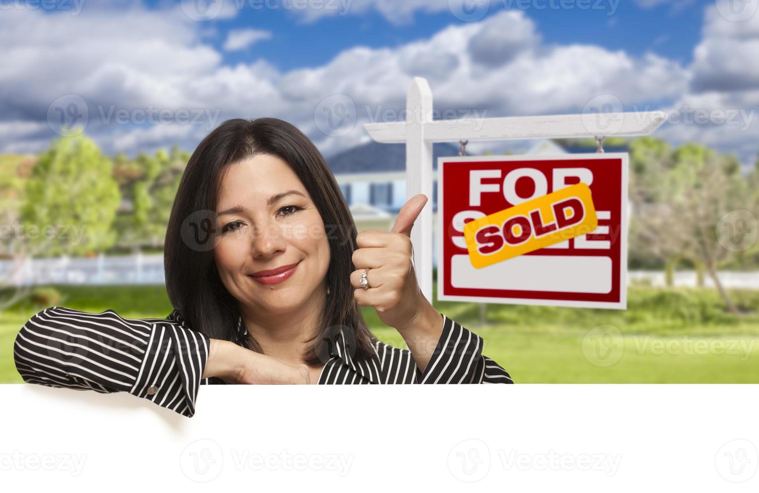 Hispanic Woman in Front of Sold For Sale Sign, House photo