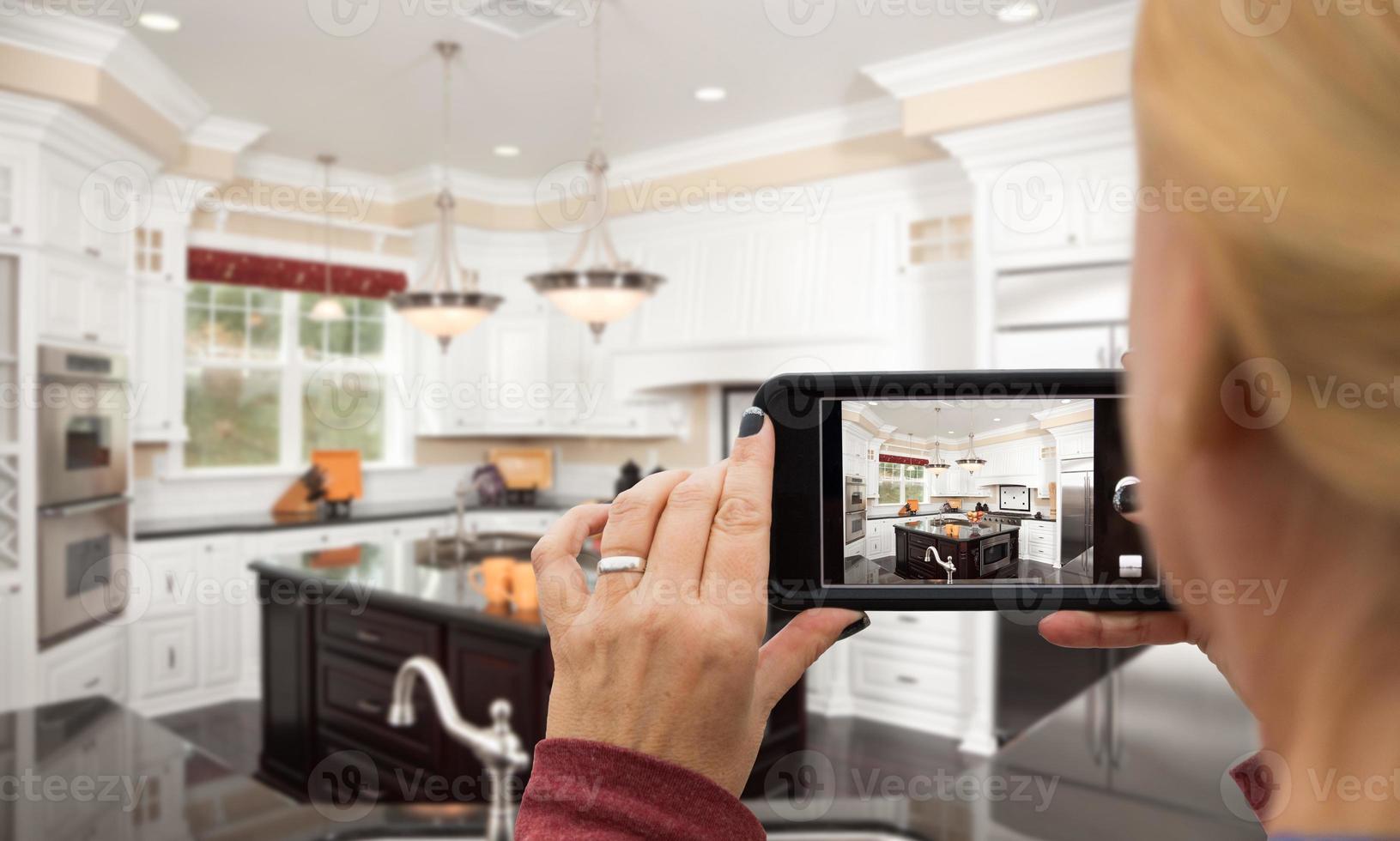 Woman Taking Pictures of A Custom Kitchen with Her Smart Phone photo