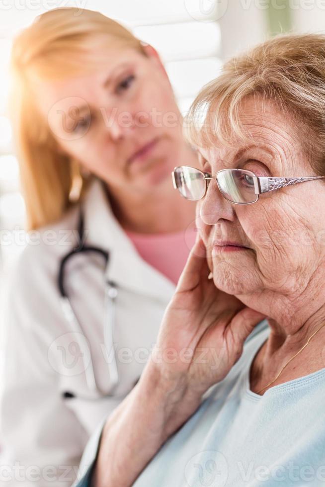 mujer adulta mayor melancólica siendo consolada por una doctora o enfermera foto