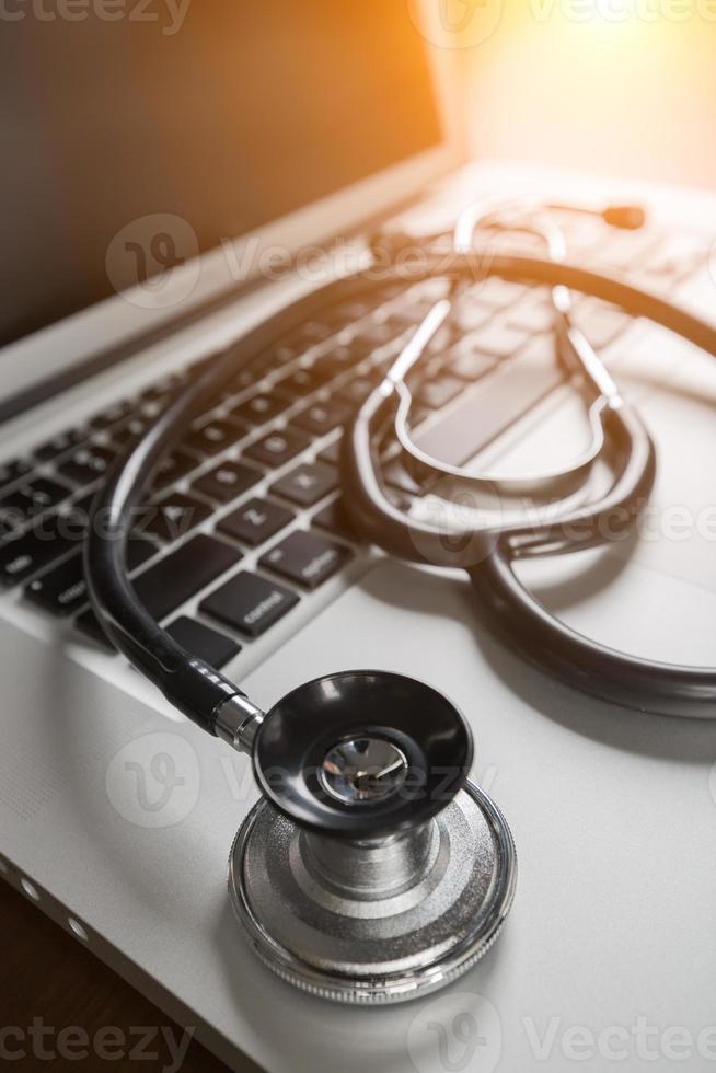 Medical Stethoscope Resting on Laptop Computer Keyboard. photo