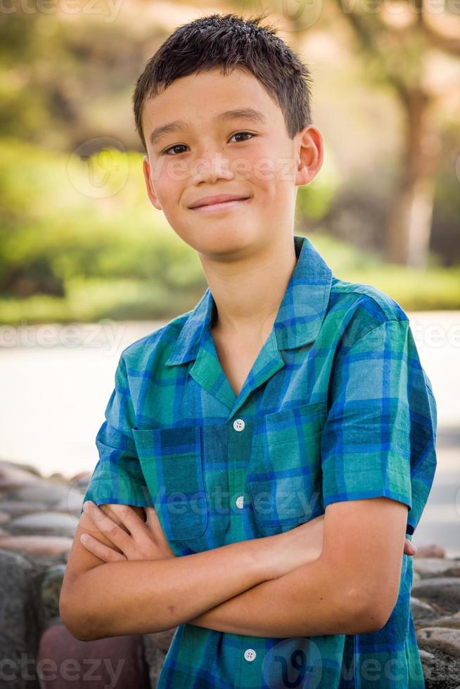 Outdoor portrait of a biracial Chinese and Caucasian boy. photo