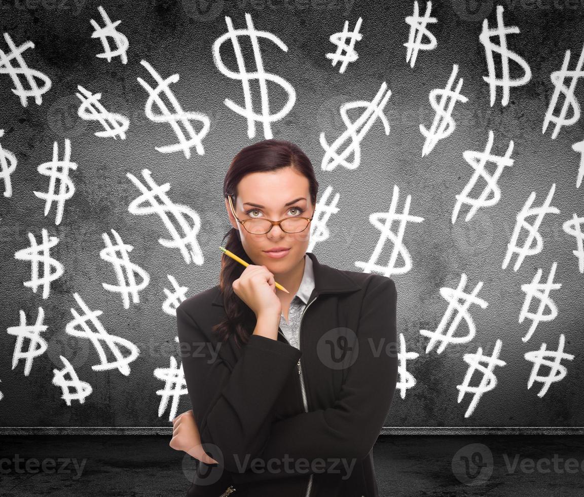 Dollar Signs Drawn on Wall Behind Young Adult Woman with Pencil photo