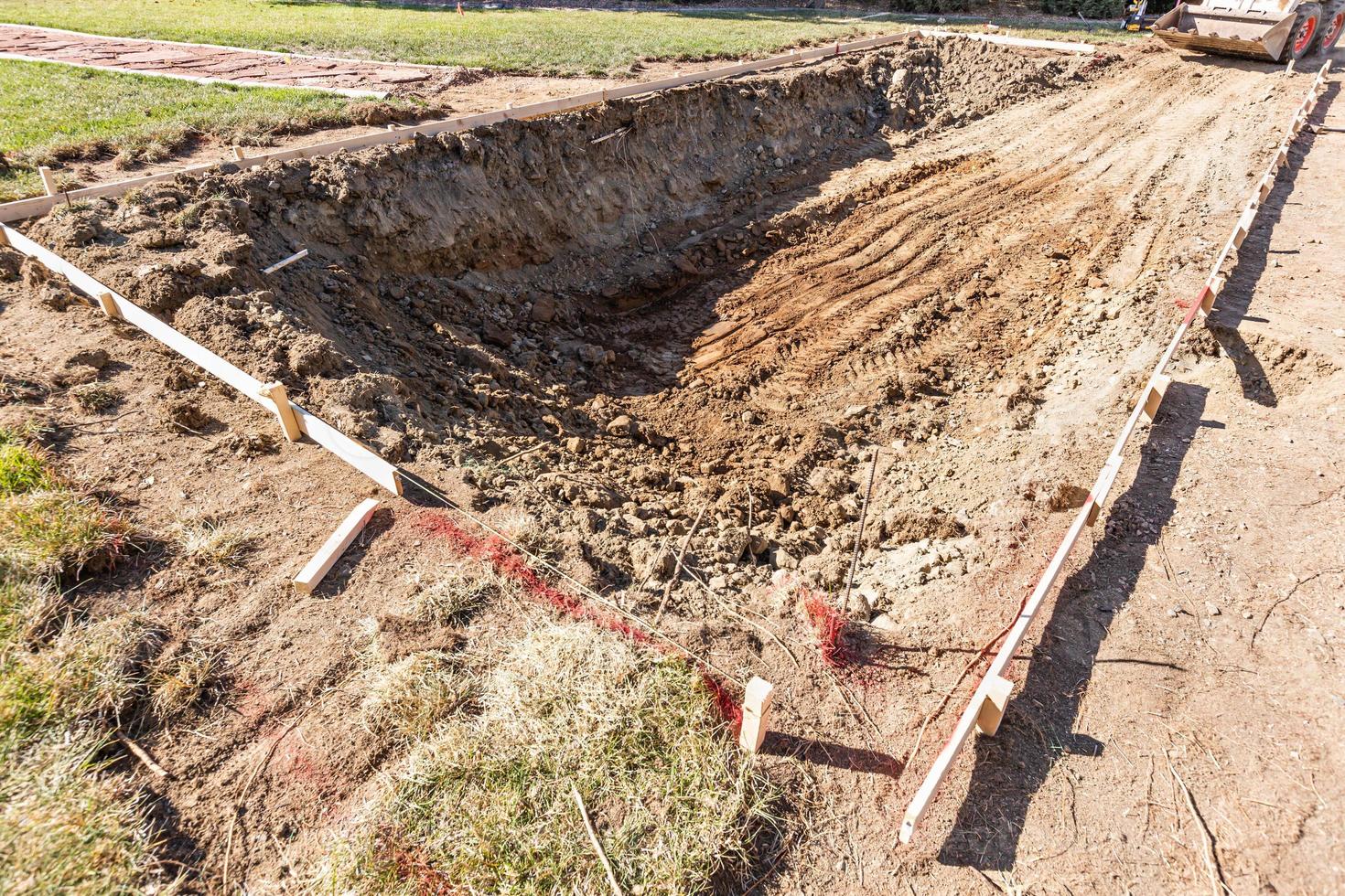 Freshly Dug Hole In Yard Preparing For Swimming Pool Installation photo