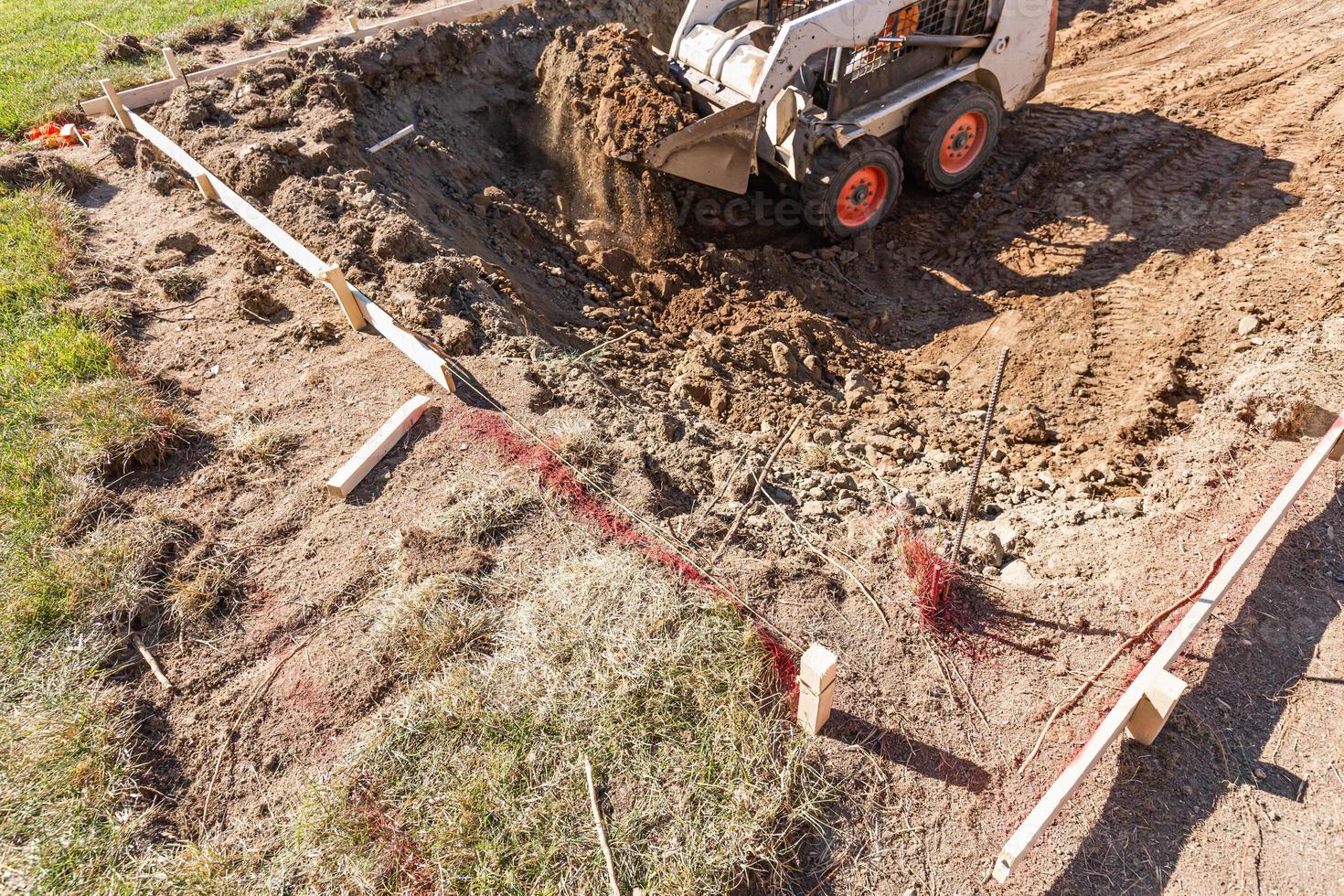 Small Bulldozer Digging In Yard For Pool Installation photo