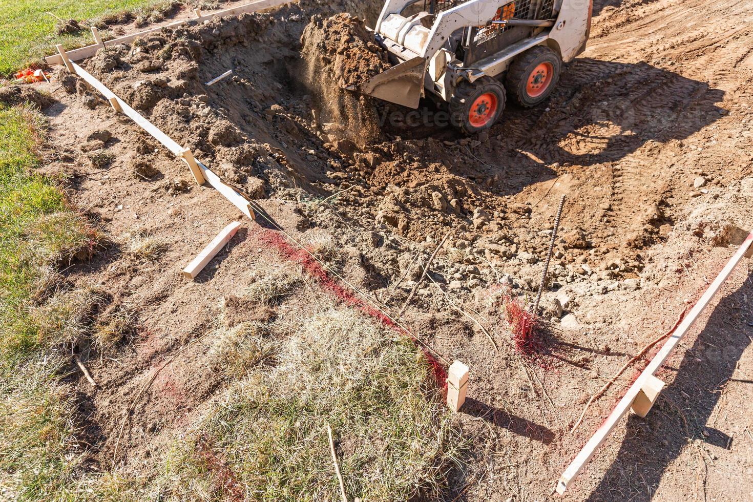 excavadora pequeña excavando en el patio para la instalación de piscinas foto