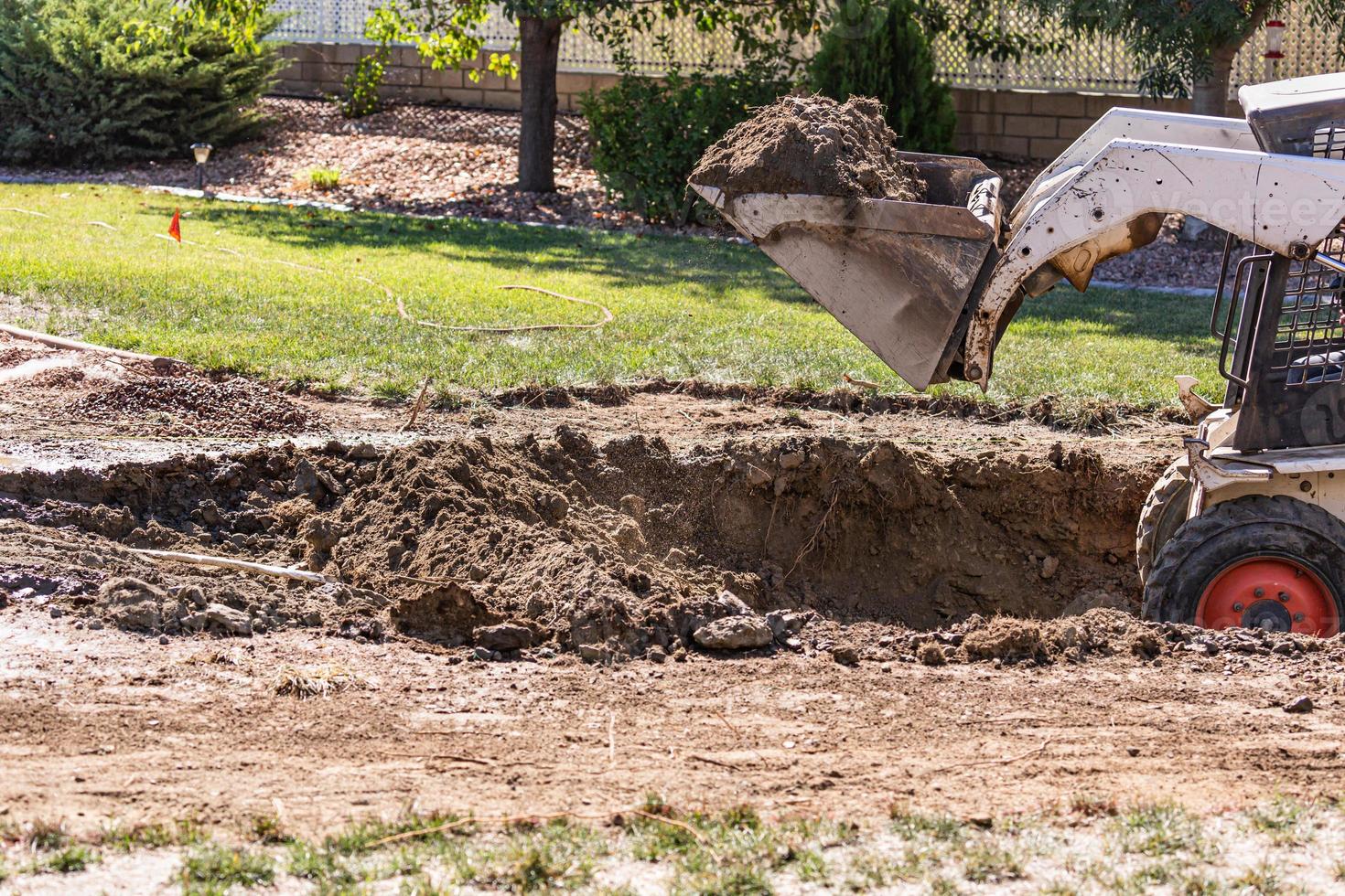 excavadora pequeña excavando en el patio para la instalación de piscinas foto