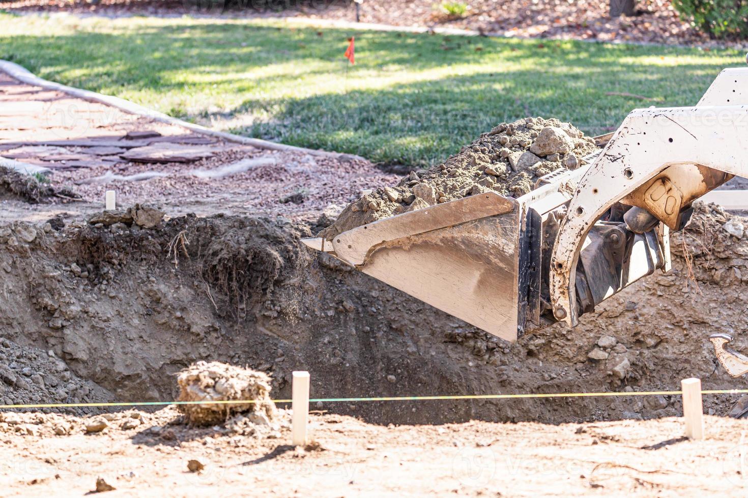 Small Bulldozer Digging In Yard For Pool Installation photo