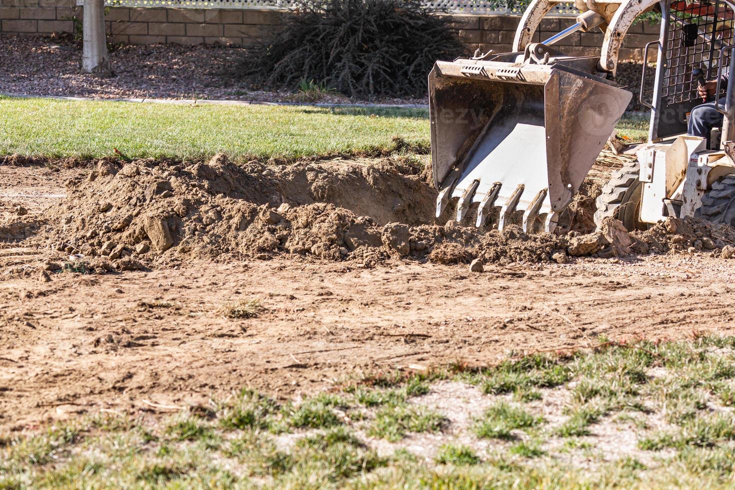 Small Bulldozer Digging In Yard For Pool Installation photo