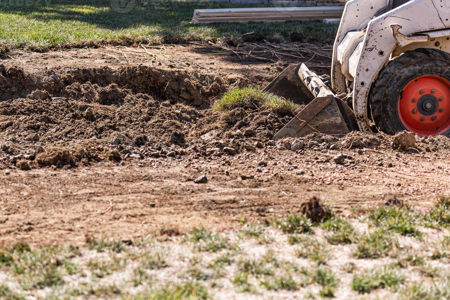 Small Bulldozer Digging In Yard For Pool Installation photo