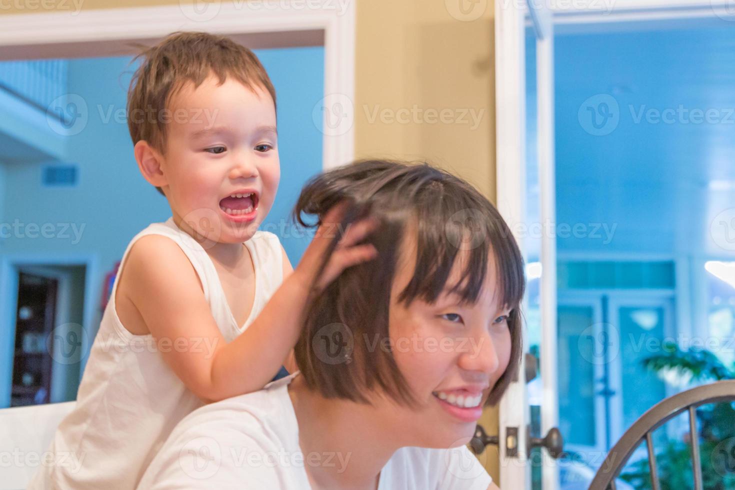 Happy Mixed Race Chinese and Caucasian Boy Having Fun with Chinese Mother Inside House photo