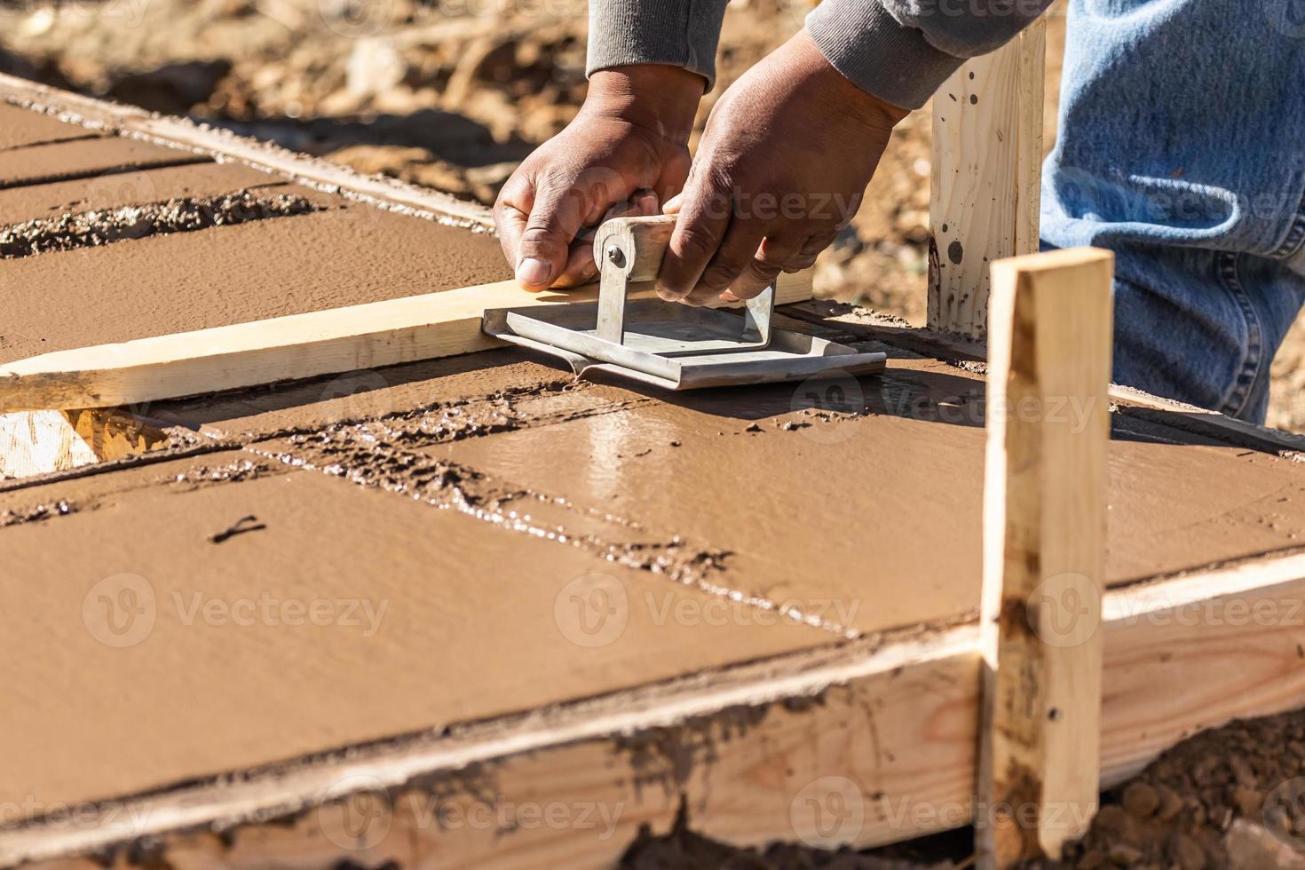 Construction Worker Using Hand Groover On Wet Cement Forming Coping Around New Pool photo