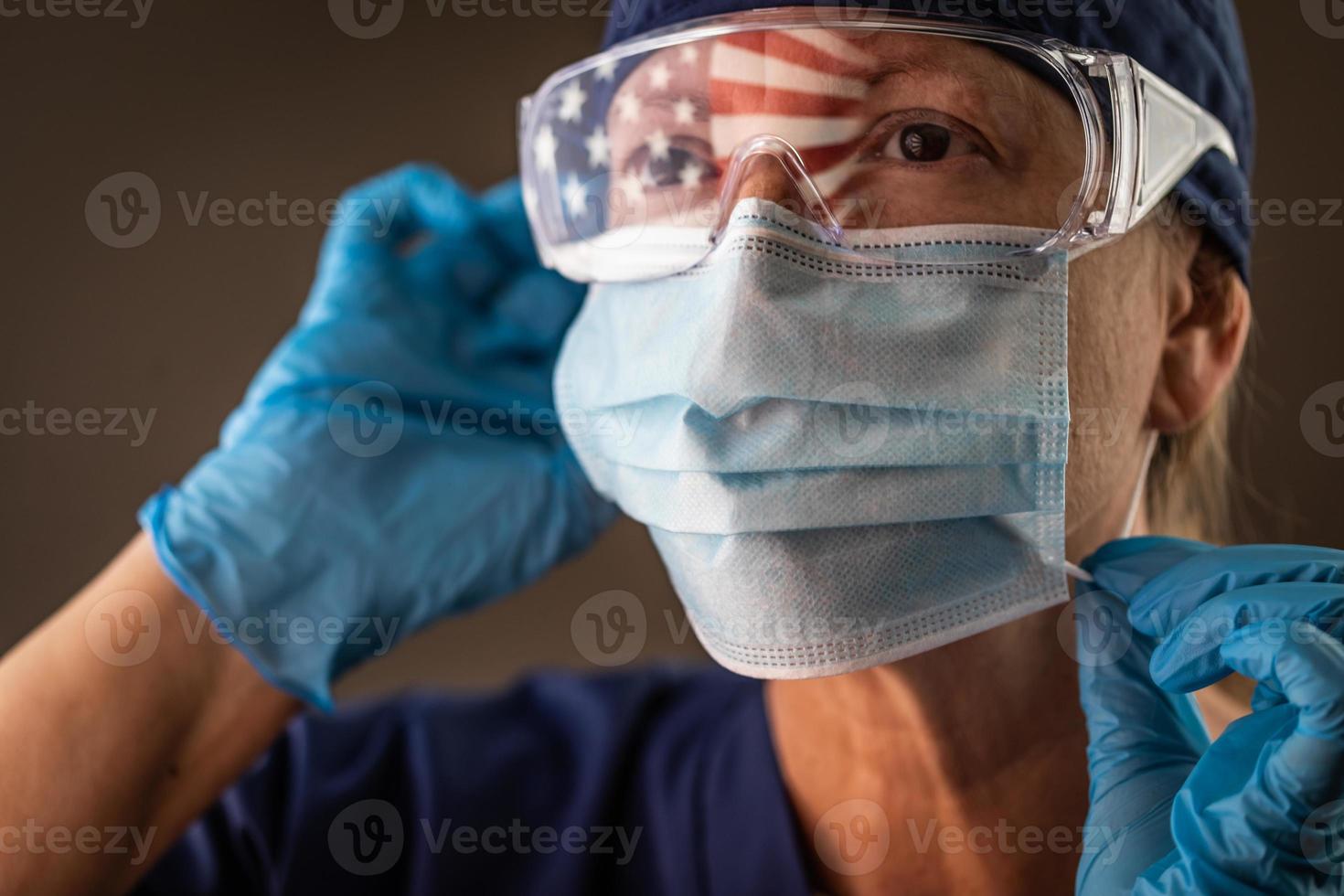 American Flag Reflecting on Female Medical Worker Wearing Protective Face Mask and Goggles photo