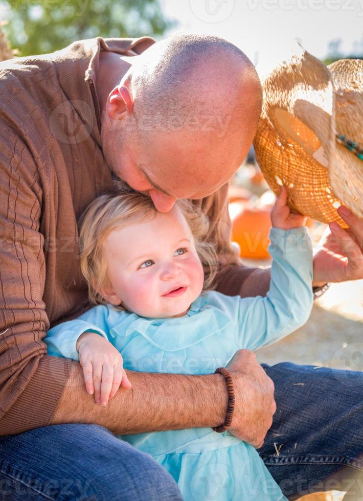 Adorable Young Family Enjoys a Day at the Pumpkin Patch. photo