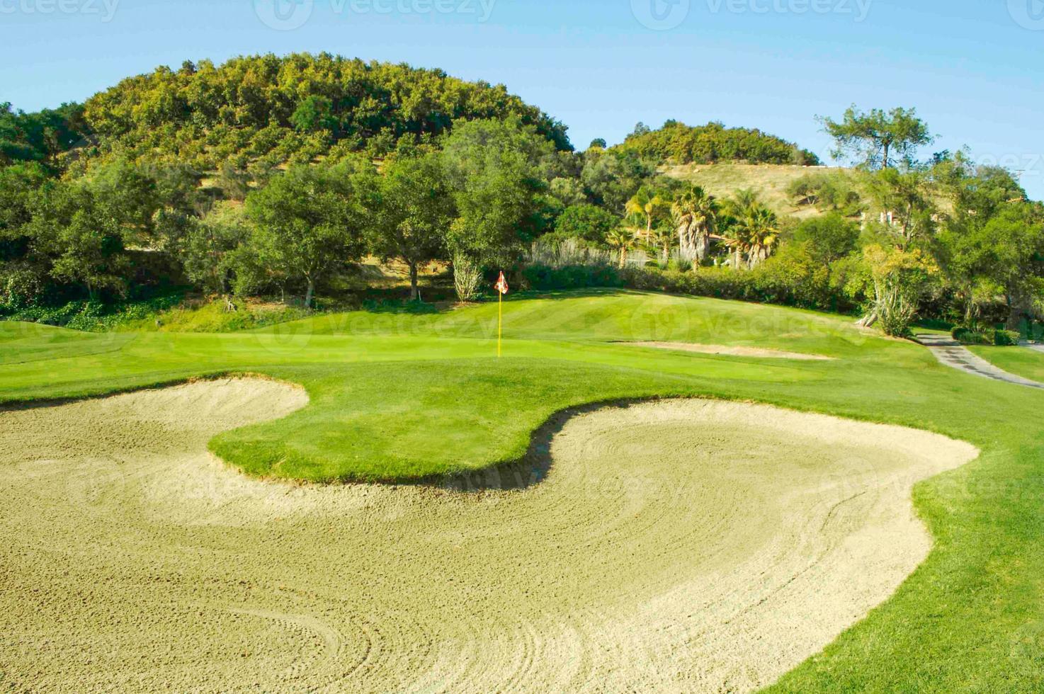 resumen del búnker de arena del campo de golf y verde con bandera. foto