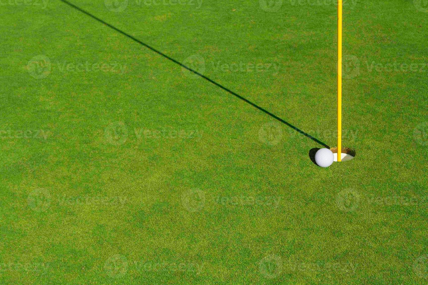 Close-up of Golf Course Green, Flag Pin and Ball. photo