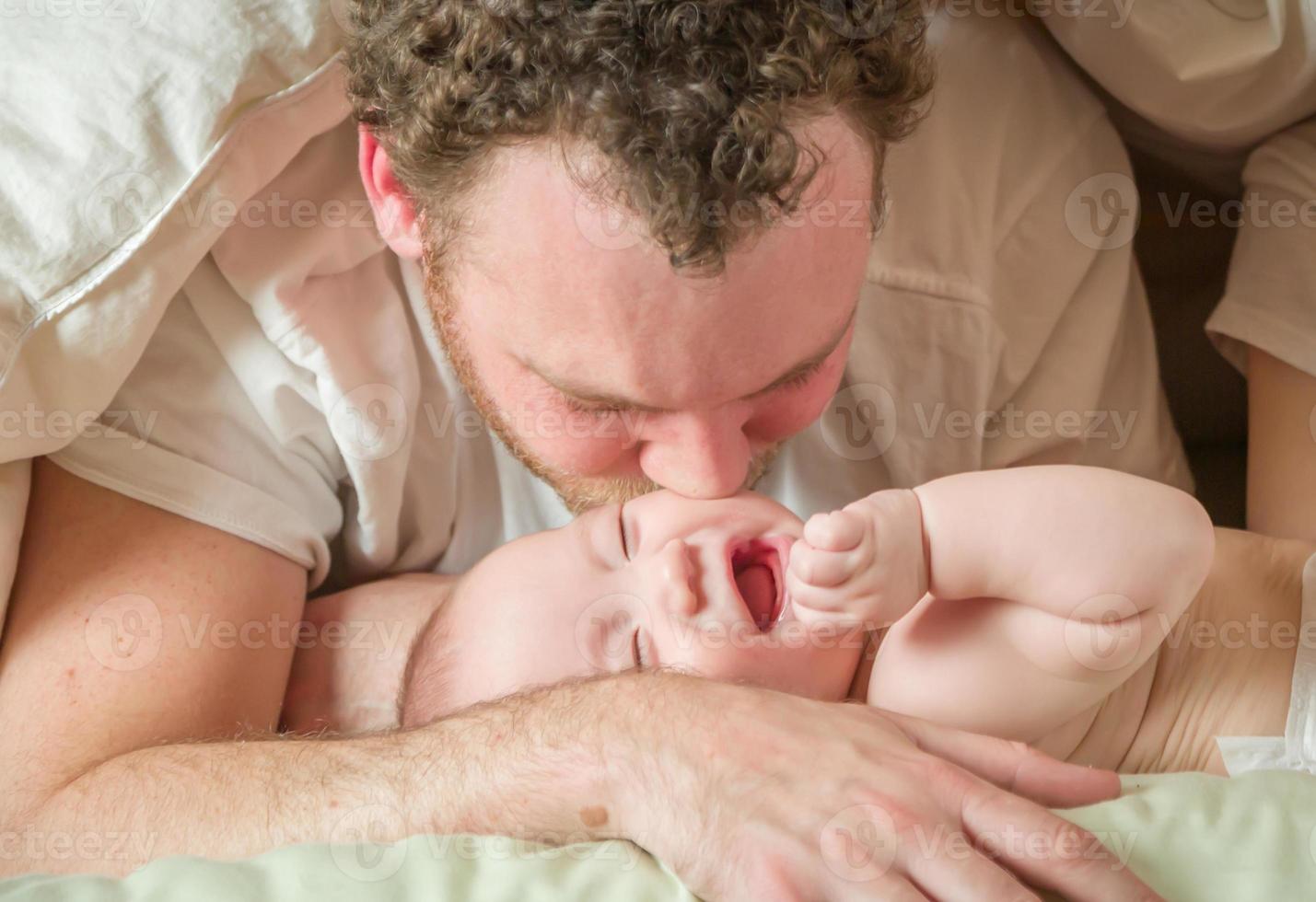 Mixed Race Chinese and Caucasian Baby Boy Laying In Bed with His Parents photo