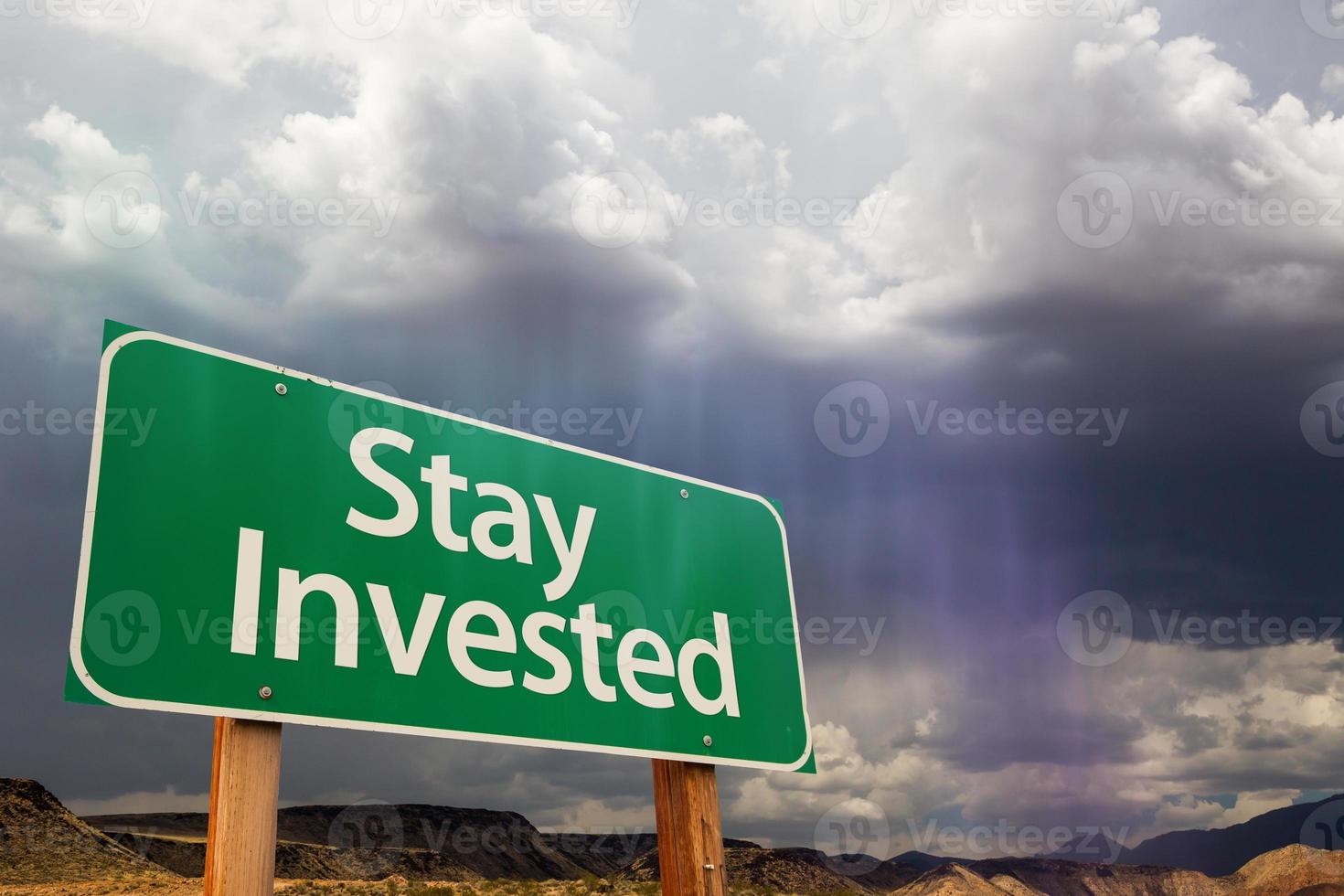 Stay Invested Green Road Sign Over Dramatic Clouds and Sky. photo