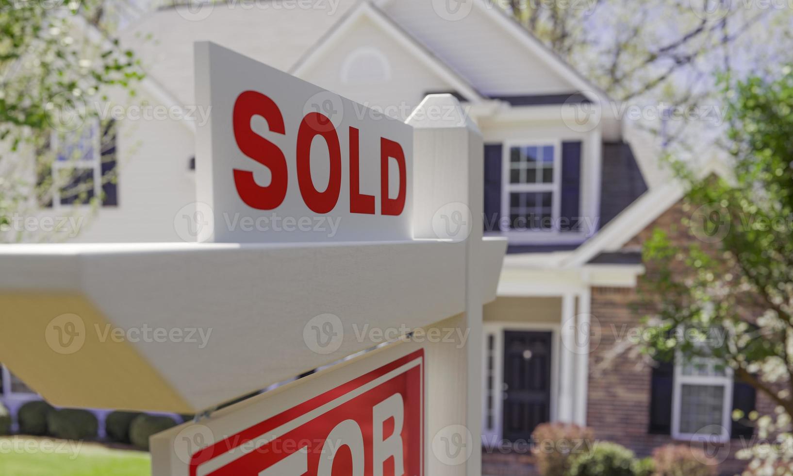 primer plano de cartel vendido en casa en venta letrero de bienes raíces frente a casa nueva. foto