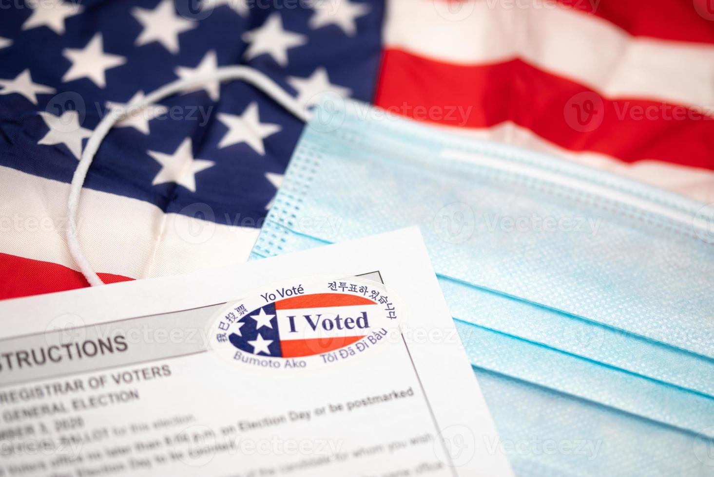 Voting Instructions and I Voted Sticker On Medical Face Mask Laying on American Flag photo