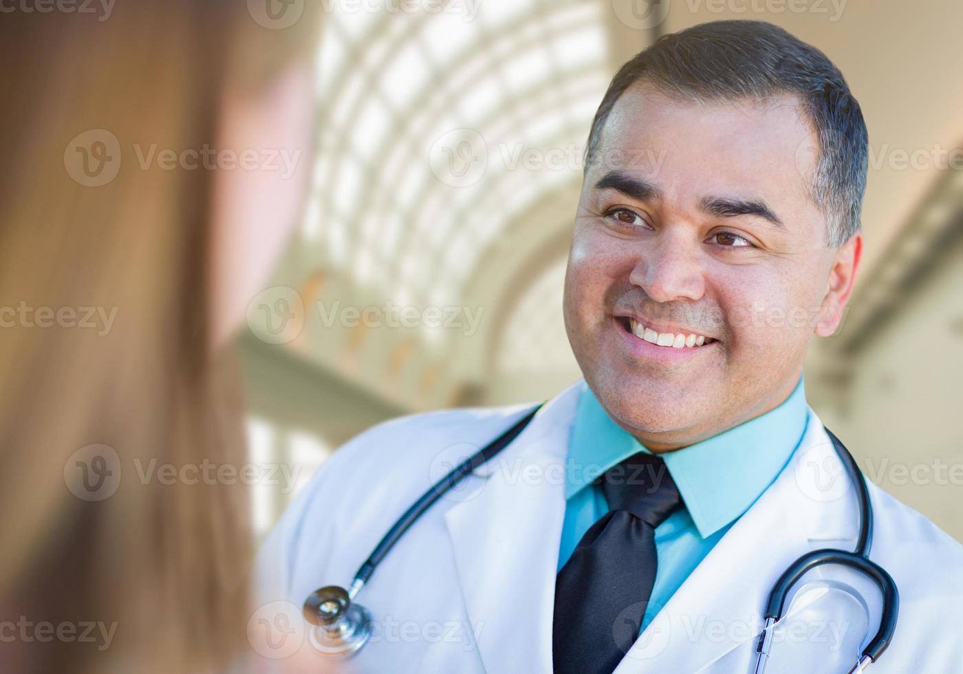 médico o enfermero hispano hablando con un paciente en el interior foto