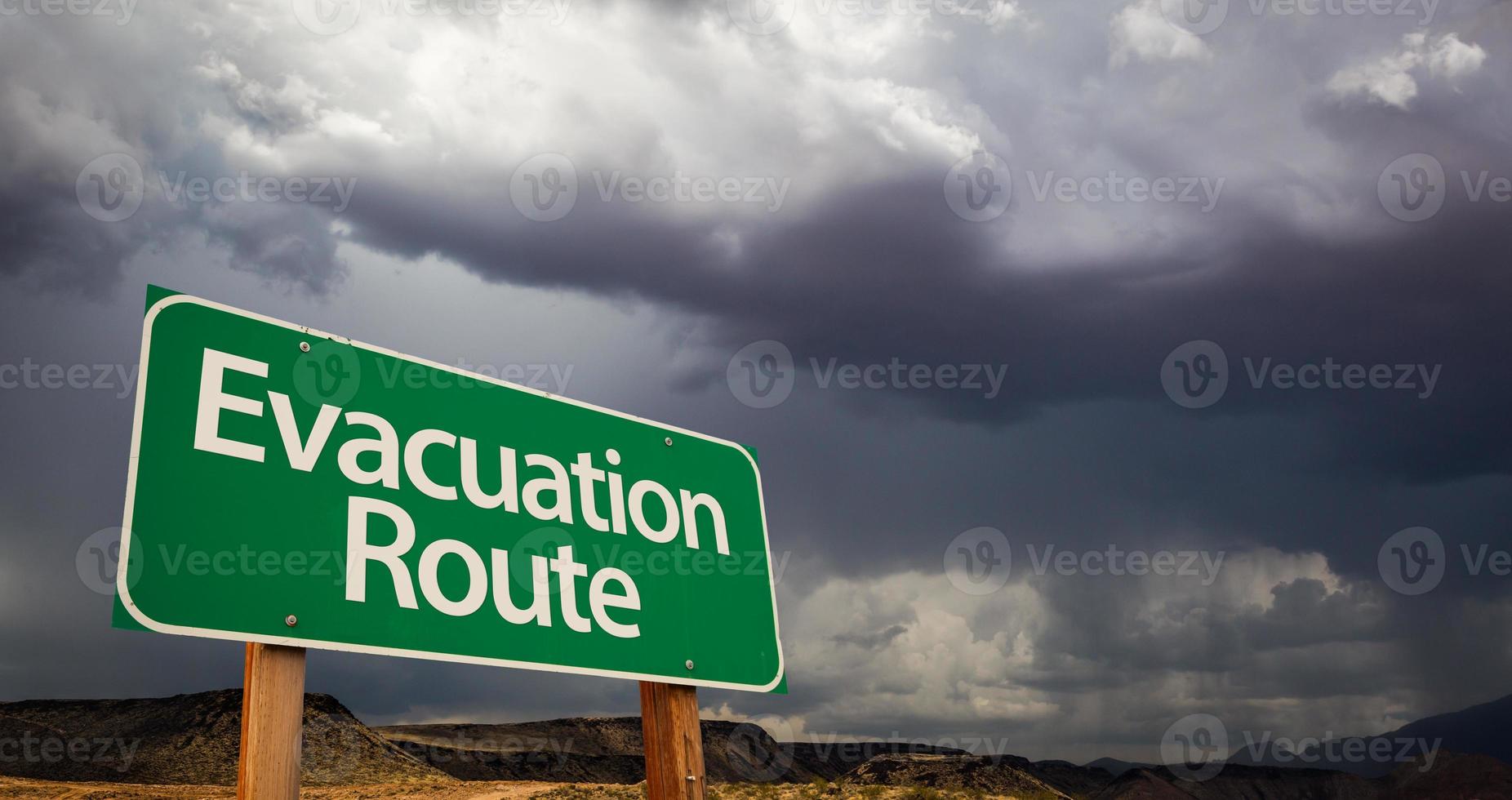 ruta de evacuación señal de carretera verde y nubes tormentosas foto