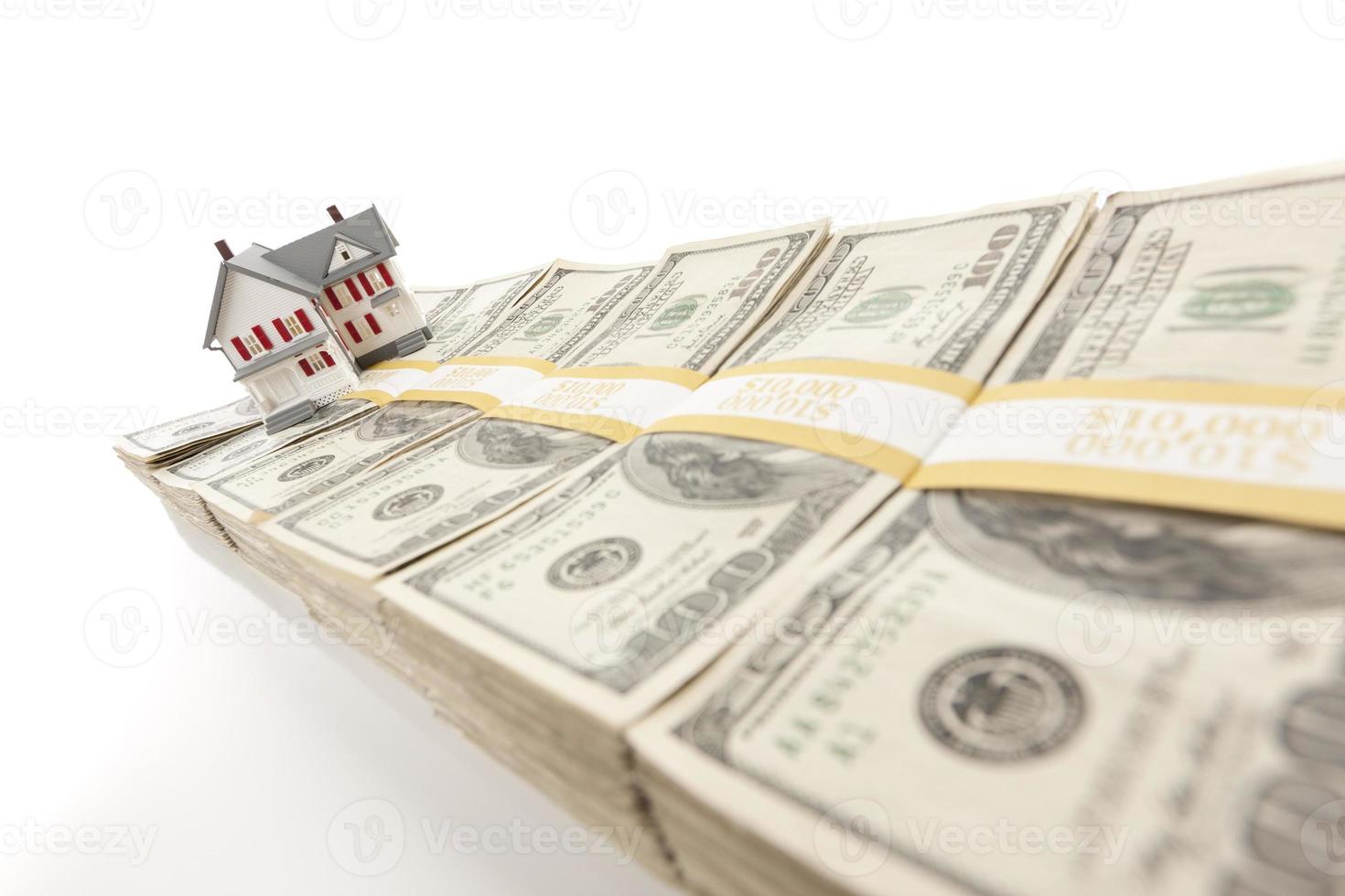 Small House on Row of Hundred Dollar Bill Stacks photo