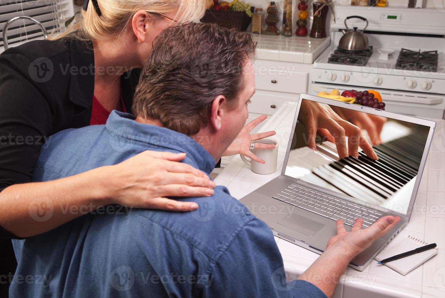 Couple In Kitchen Using Laptop - Music Performance photo