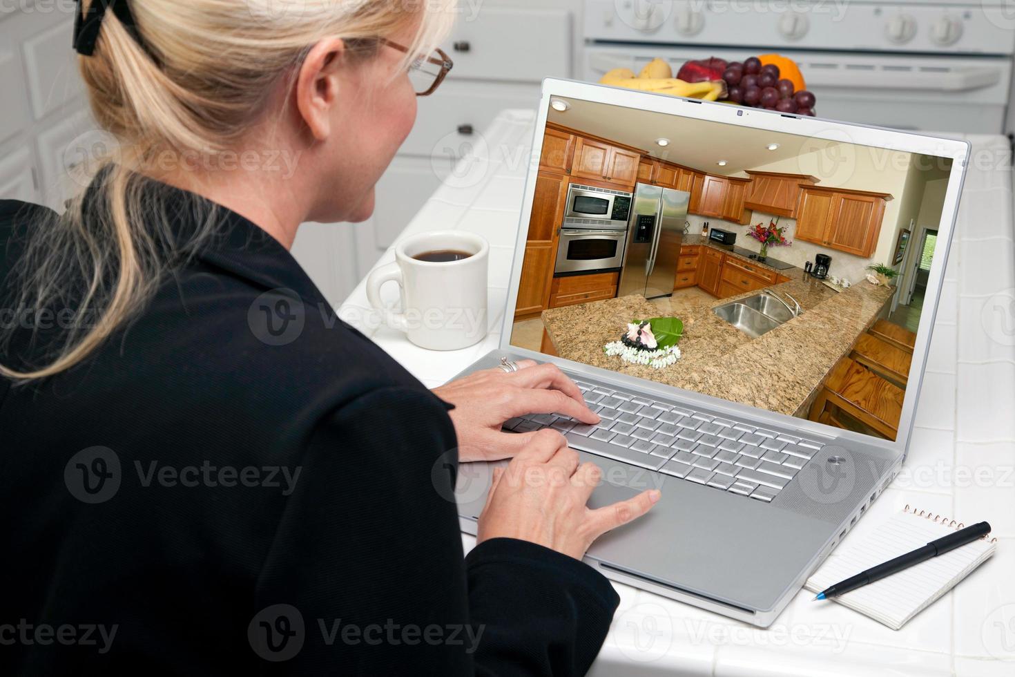 Woman In Kitchen Using Laptop - Home Improvement photo
