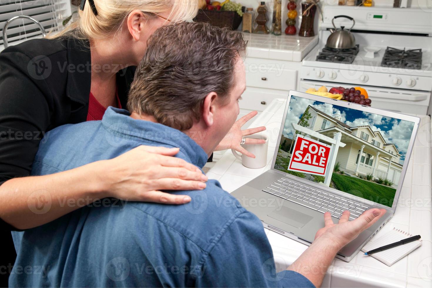 Couple In Kitchen Using Laptop - Real Estate photo
