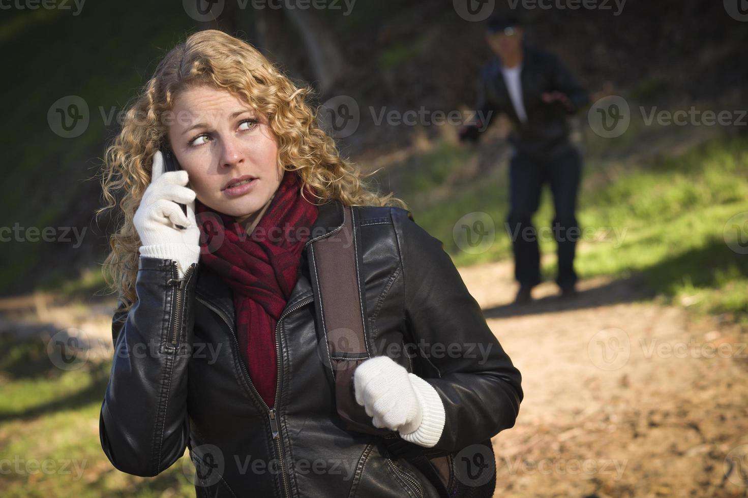 Pretty Young Teen Girl Walking with Man Lurking Behind Her photo